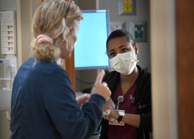Danielle Gonzalez, right, talks with Michelle Lucas, senior nurse practitioner in the cardiology department at the University of Maryland St.  Joseph Medical Center.  Gonzalez is a graduate of CCBC and participates in the Health Promotion Program, which provides a group of CCBC nursing students with guaranteed education and work at the University of Maryland St.  Joseph Medical Center after graduation.  (Lloyd Fox/Staff)
